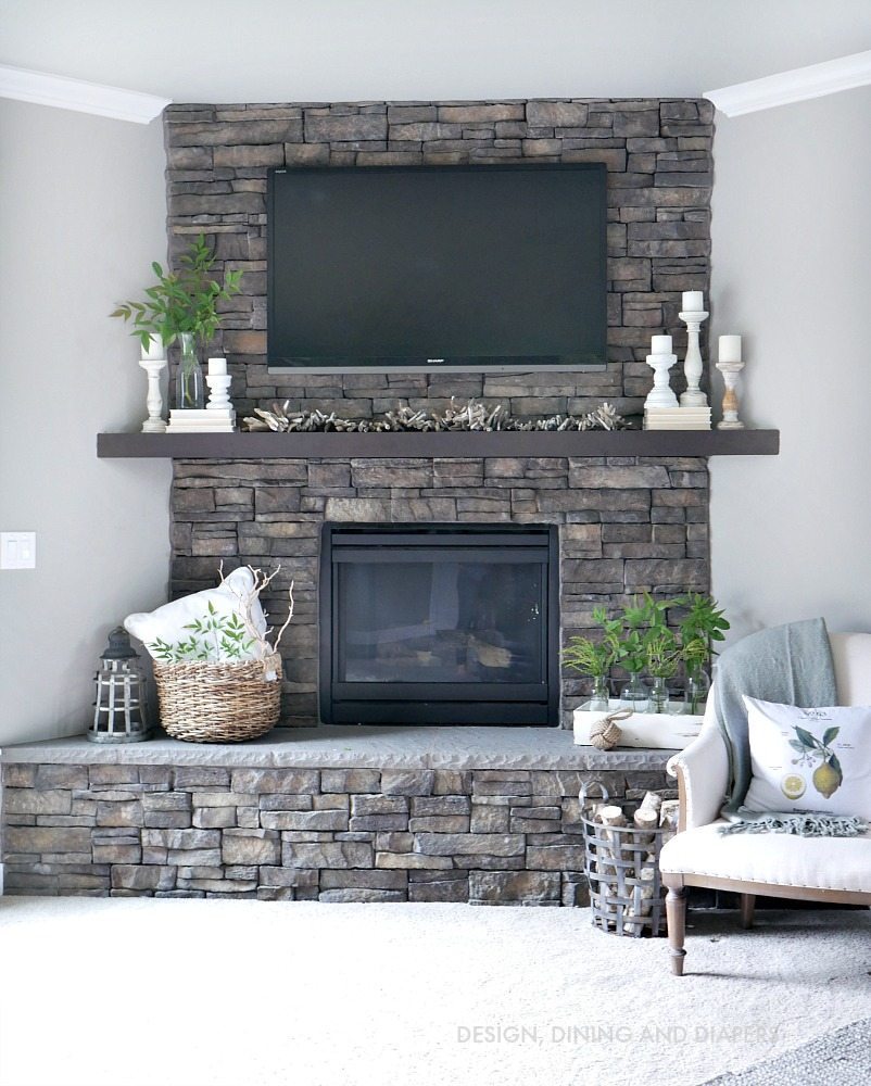 Neutral Summer Mantel with stone fireplace and hearth. Love the touches of soft white candles and books to make it a romantic summer look. 