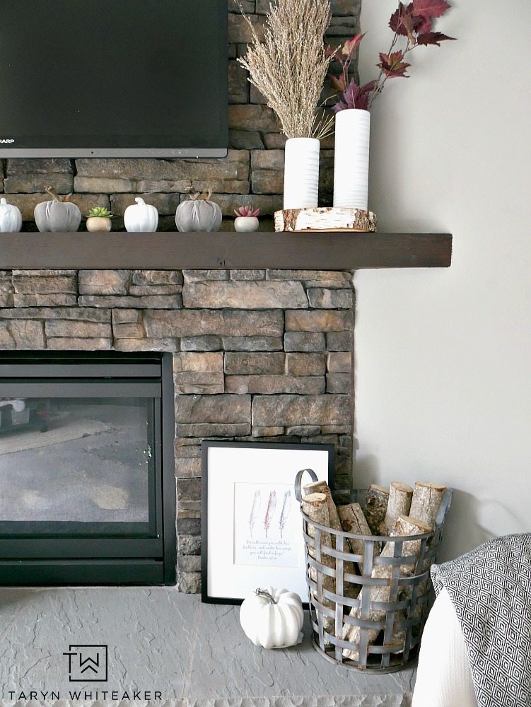 Create a modern boho fall mantel display using a mixture of deep reds, neutrals tones and lots of texture. This is a great look for fall with the earth tones against the stone fireplace. 