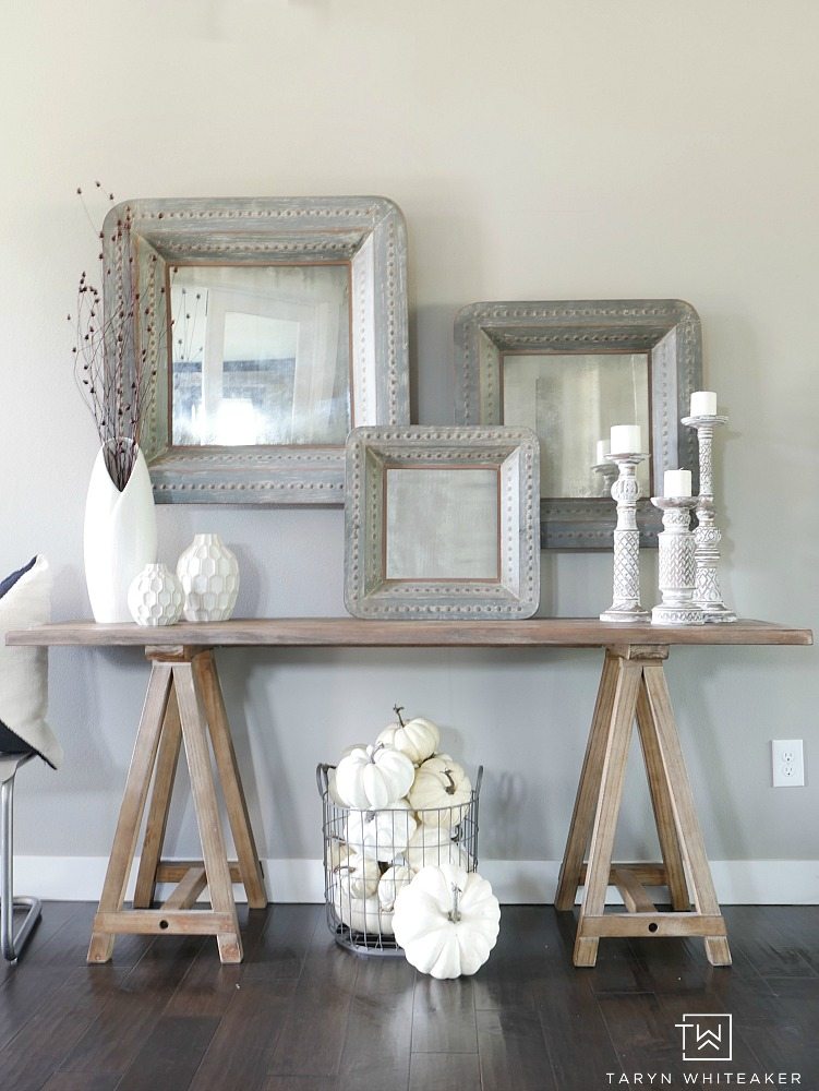 Add subtle touches of fall to your entry way with a few rustic branches, cozy candle sticks and a basket full of white pumpkins! This simple fall entry way is elegant yet festive. 