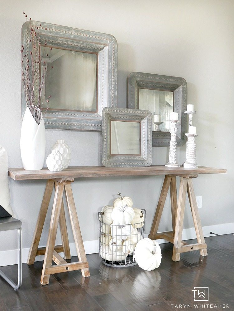 Add subtle touches of fall to your entry way with a few rustic branches, cozy candle sticks and a basket full of white pumpkins! This simple fall entry way is elegant yet festive. 