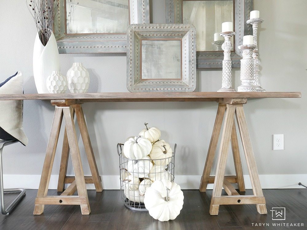 Add subtle touches of fall to your entry way with a few rustic branches, cozy candle sticks and a basket full of white pumpkins! This simple fall entry way is elegant yet festive. 