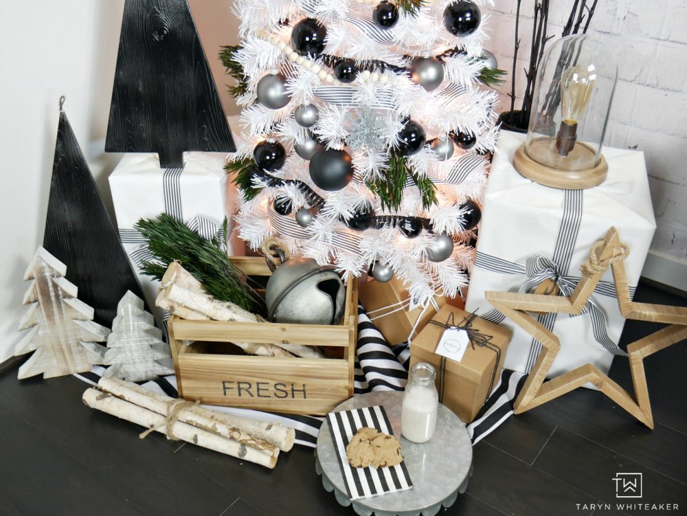 Taryn creates this Modern Black and White Christmas Tree display in her home using a tall white skinny tree with black and silver ornaments and wood!