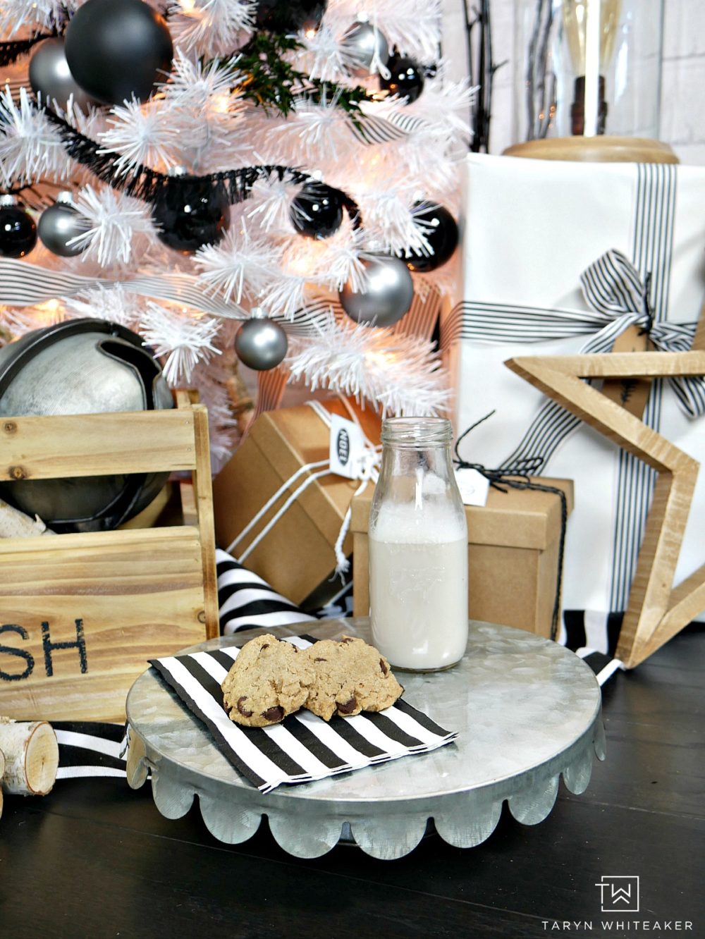 Taryn creates this Modern Black and White Christmas Tree display in her home using a tall white skinny tree with black and silver ornaments and wood!