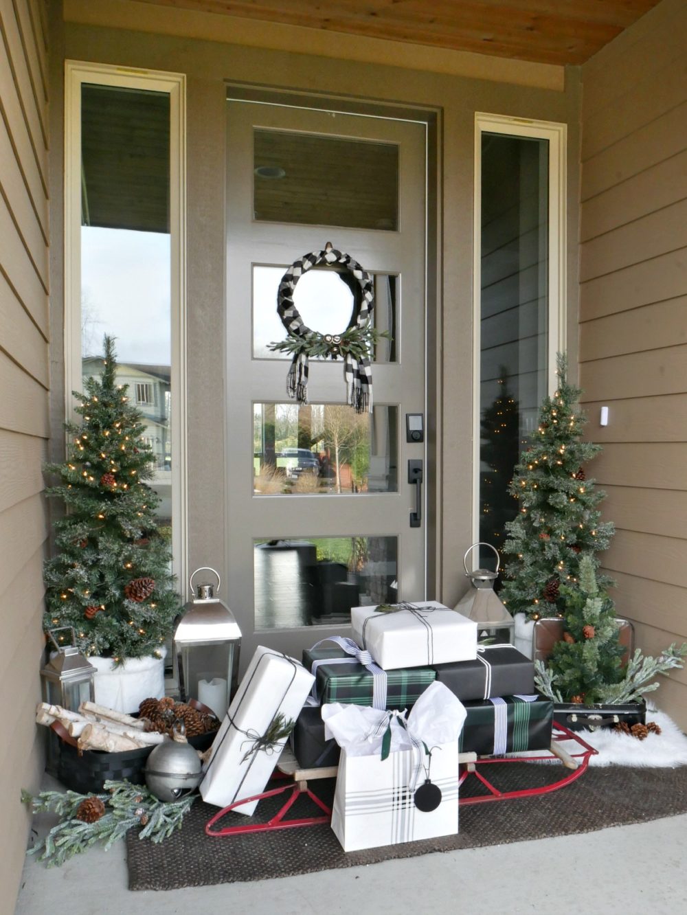 Green and Black Christmas Porch featuring mini trees, a sweater wreath and lots of wintery accents for a festive yet elegant look!