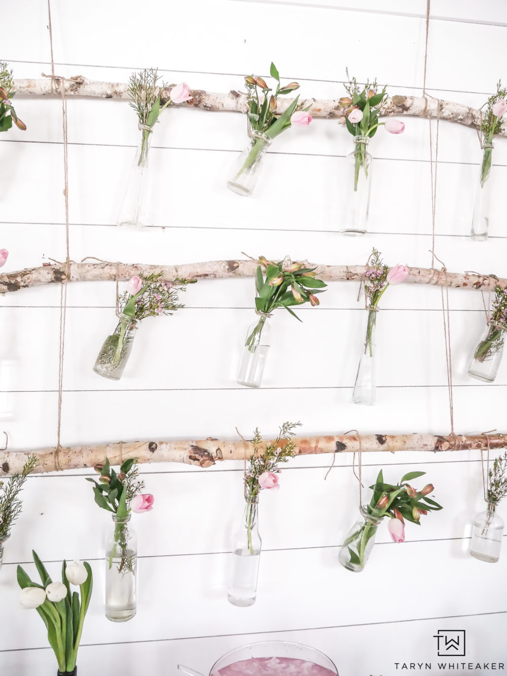 Create this hanging branch floral display using birch branches and fresh garden flowers with pops of pink!