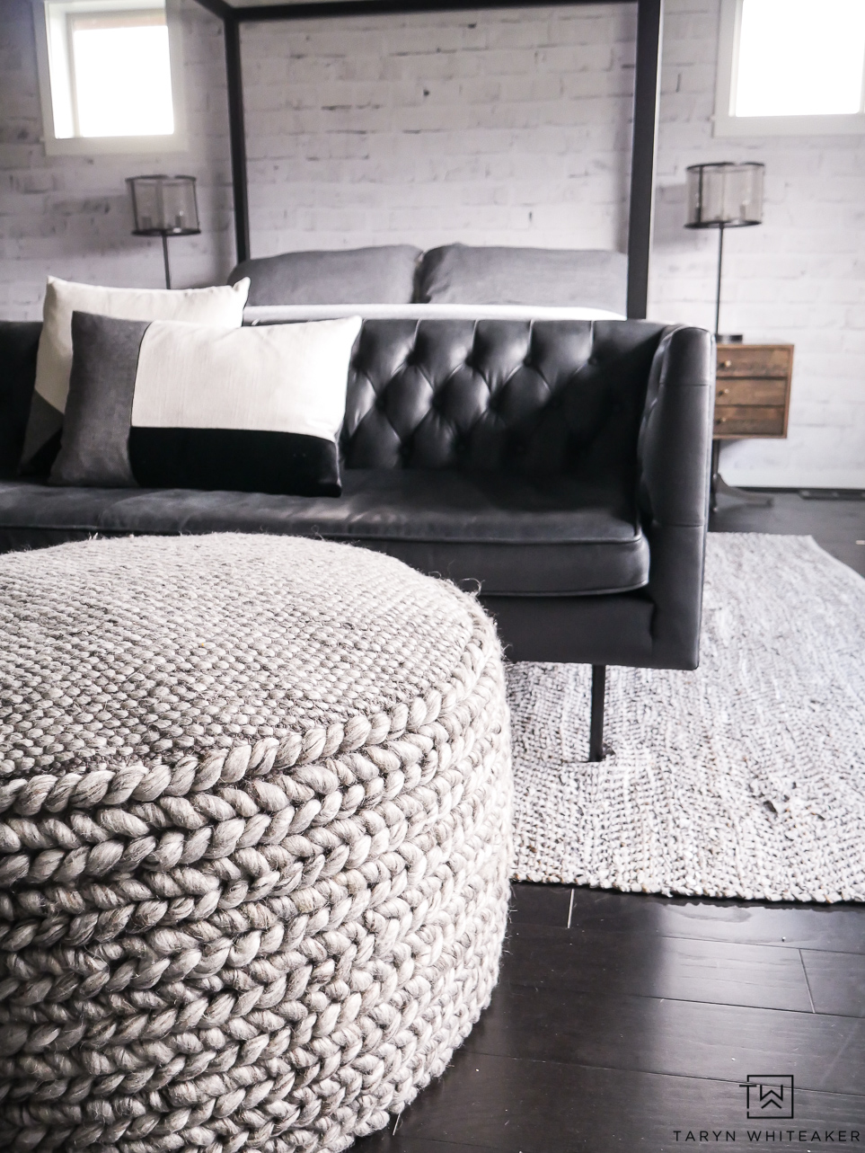 Industrial modern seating area for a bedroom complete with a black leather modern Chesterfield sofa. 