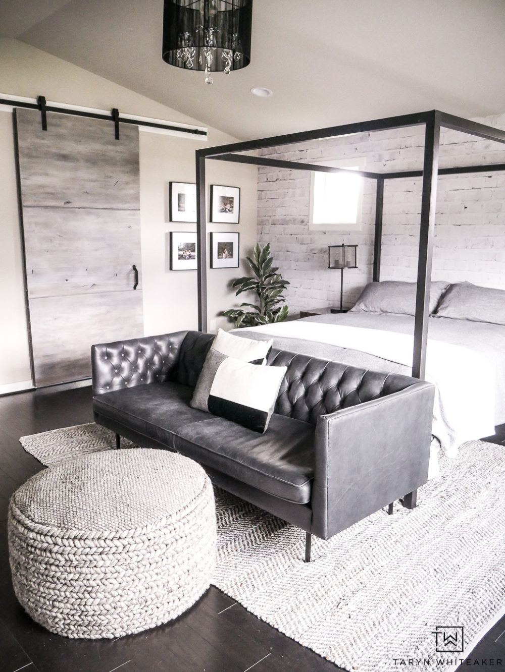 Create a cozy but modern Master Bedroom Seating Area by placing a sofa in front of a canopy and finishing it off with a textured gray ottoman and rug. 