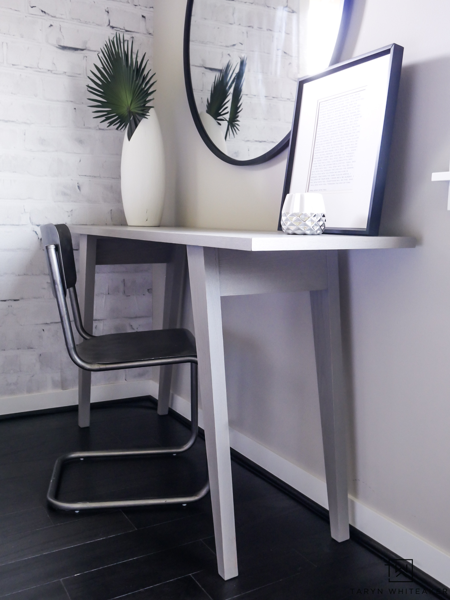 This mid-century modern console table has such a great gray finish paired with the metal chair and round black mirror. 