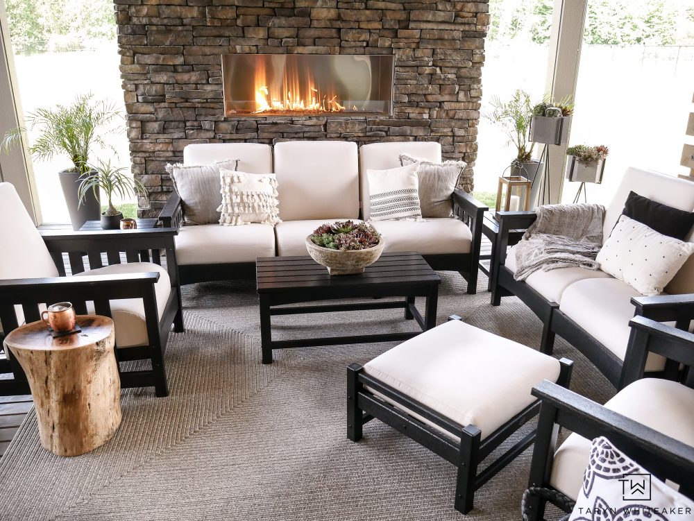 Check out this beautiful outdoor living space with black and white outdoor furniture! I love the stone fireplace. 