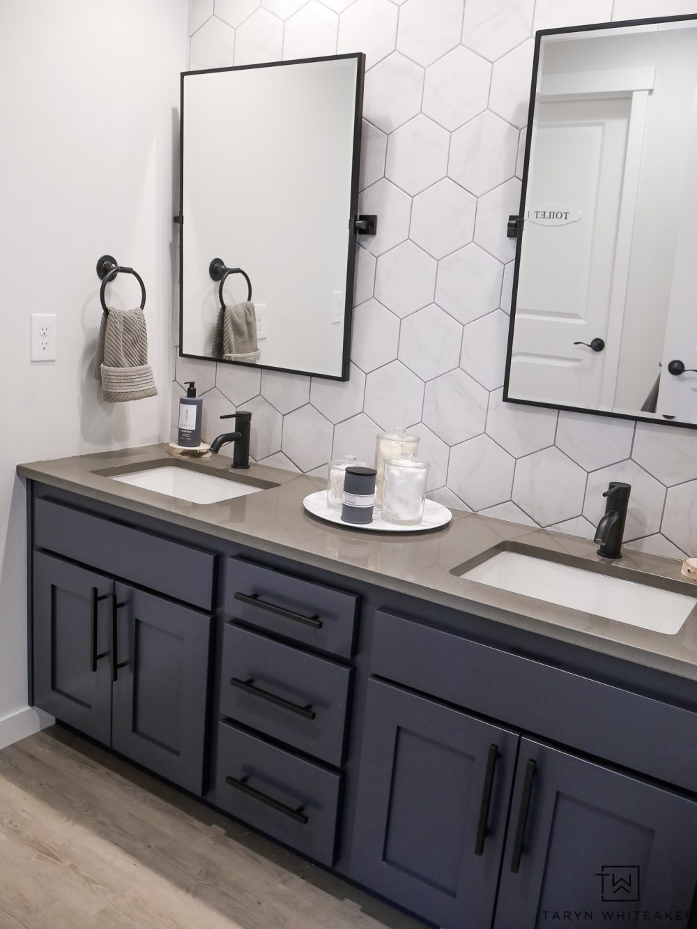 Check out with Kids' Jack-n-Jill Bathroom with a Rustic Modern Look to it with large hexagon tile backsplash, industrial touches and charcoal blue cabinets! 