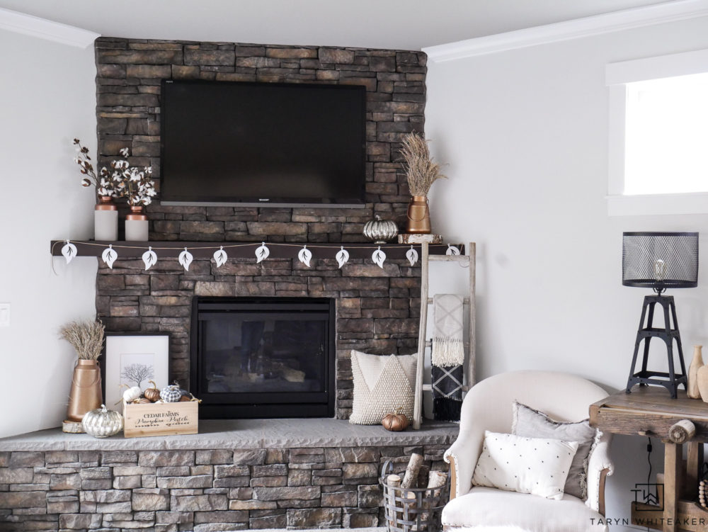 Check out this neutral fall mantel filled with pops of copper and cotton stems. Love all the natural textures against the stone fireplace. 