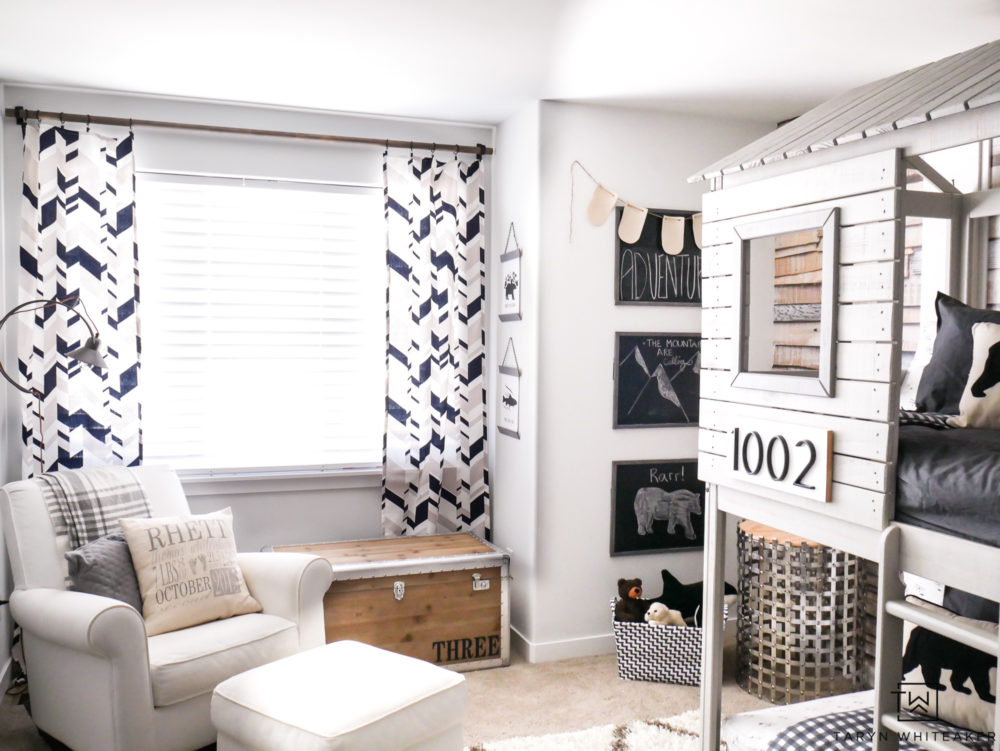 Neutral Boys room filled with cream, gray, and navy. Adorable geometric curtains mixed with plaid makes for a cute rustic modern space. 