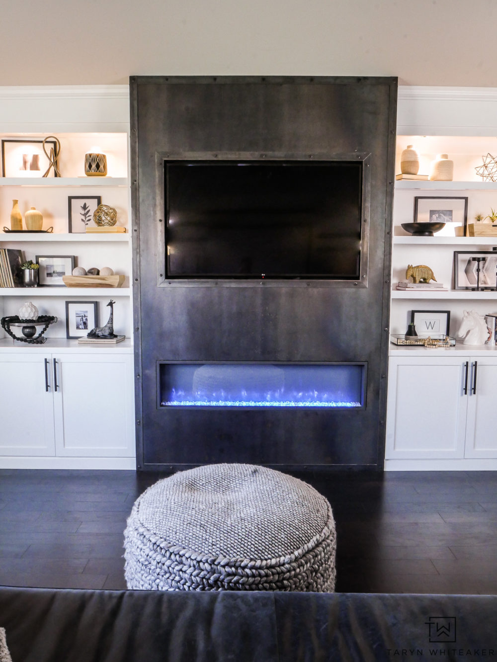 Gorgeous modern built ins with sleek steel fireplace and built in wood storage. Love the black and white decorative accessories. 