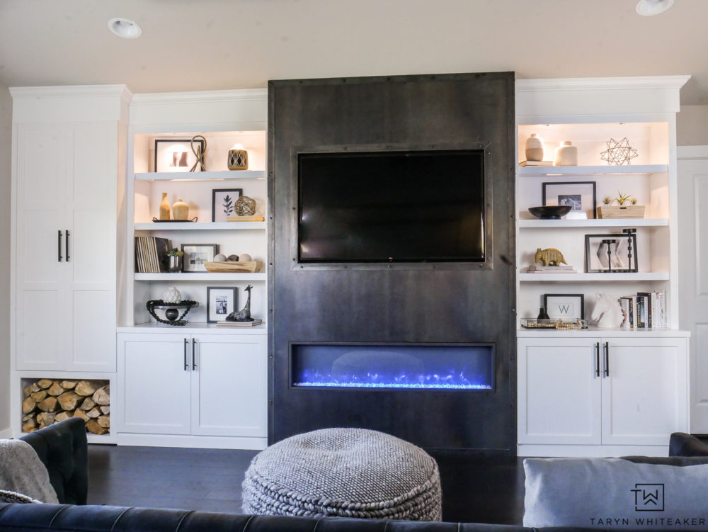 Gorgeous modern built ins with sleek steel fireplace and built in wood storage. Love the black and white decorative accessories. 