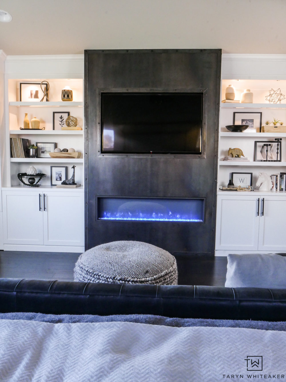 Custom white built ins with modern raw steel fireplace place as focal point. Love the black and white bedroom. 