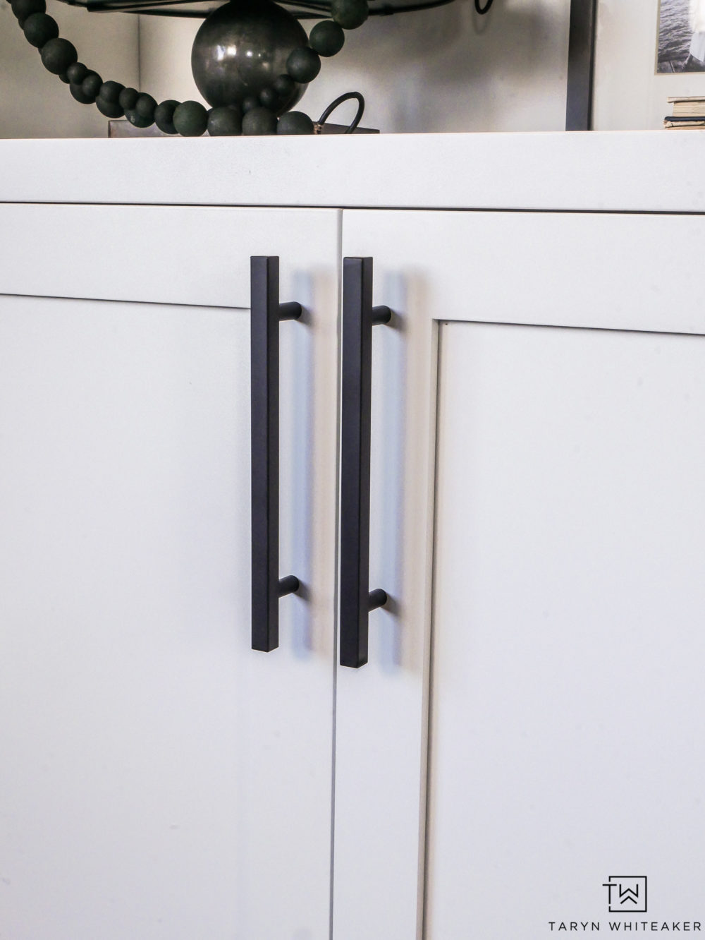 Sleek black hardware on white cabinets. 