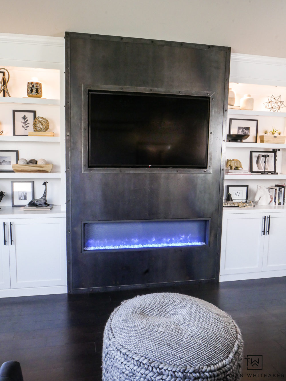 Gorgeous modern built ins with sleek steel fireplace and built in wood storage. Love the black and white decorative accessories. 