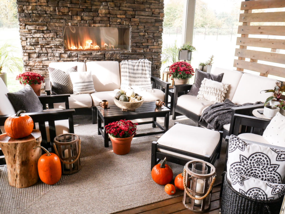 Outdoor living space in the Pacific Northwest with large stone fireplace and cozy seating area. 