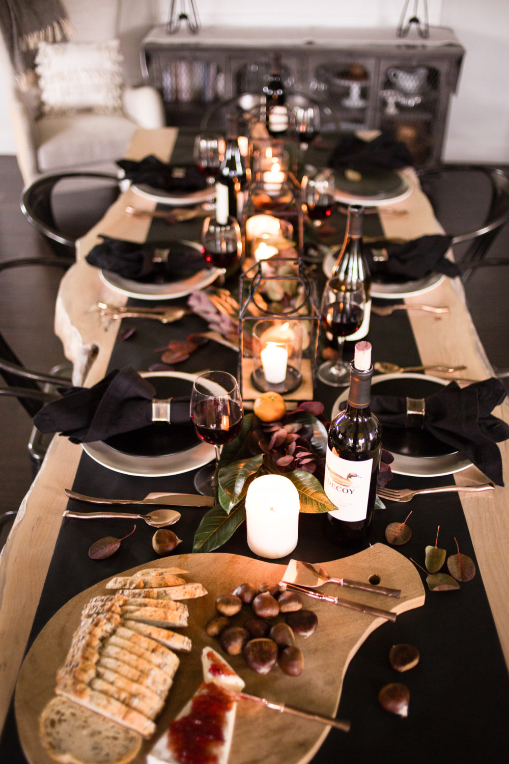 Timeless and classic, dark and moody Thanksgiving tablescape with magnolia leaves and clementine oranges with pops of copper. 