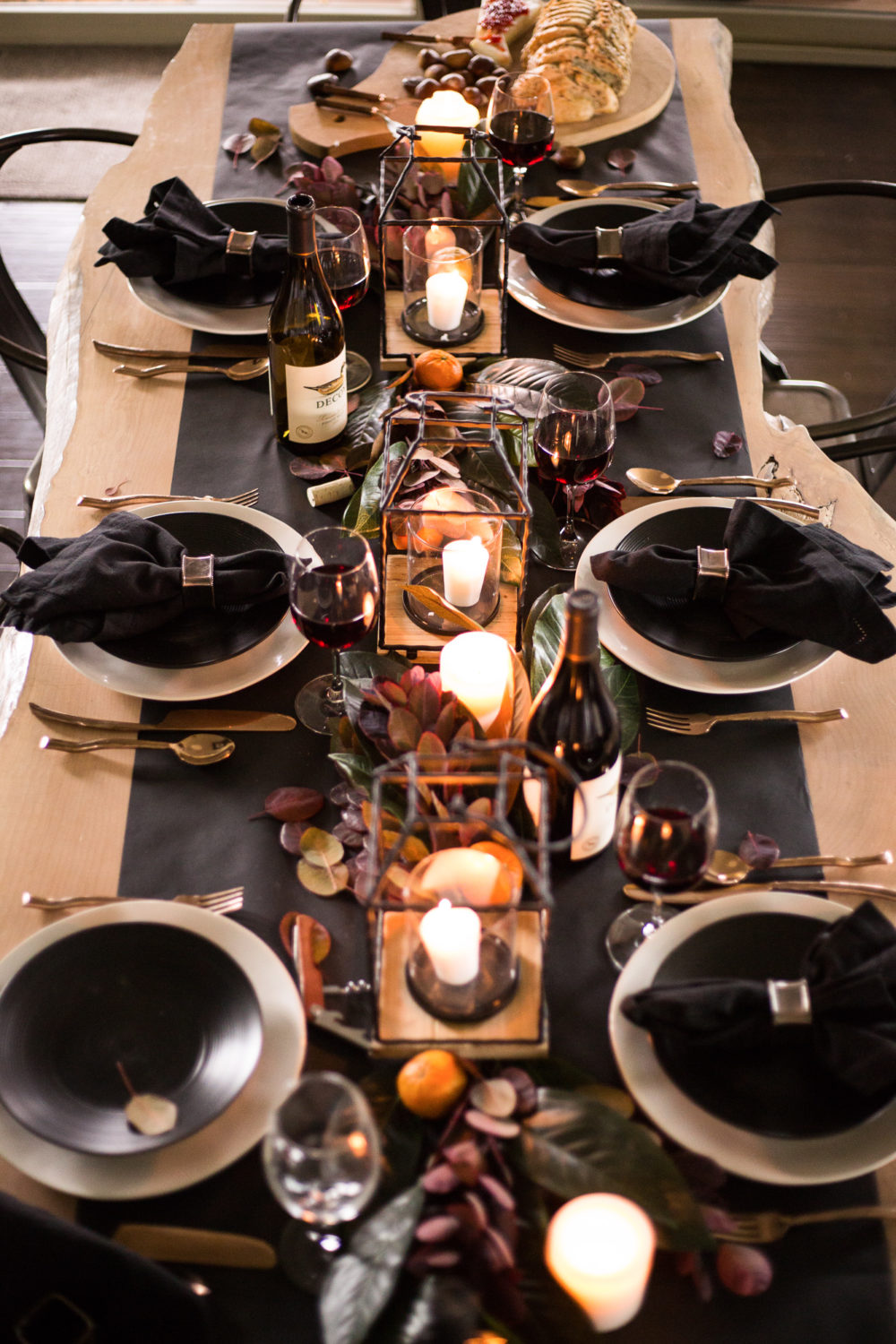 Timeless and classic, dark and moody Thanksgiving tablescape with magnolia leaves and clementine oranges with pops of copper. 