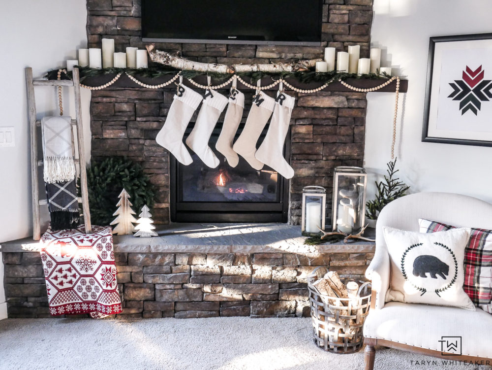 Neutral Christmas mantel on large stone fireplace. Love the subtle pops of red and green and plaid!