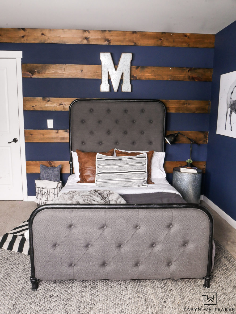 Rustic boy's room with dark navy walls and wood accents. Love the industrial decor and pops of pattern. 