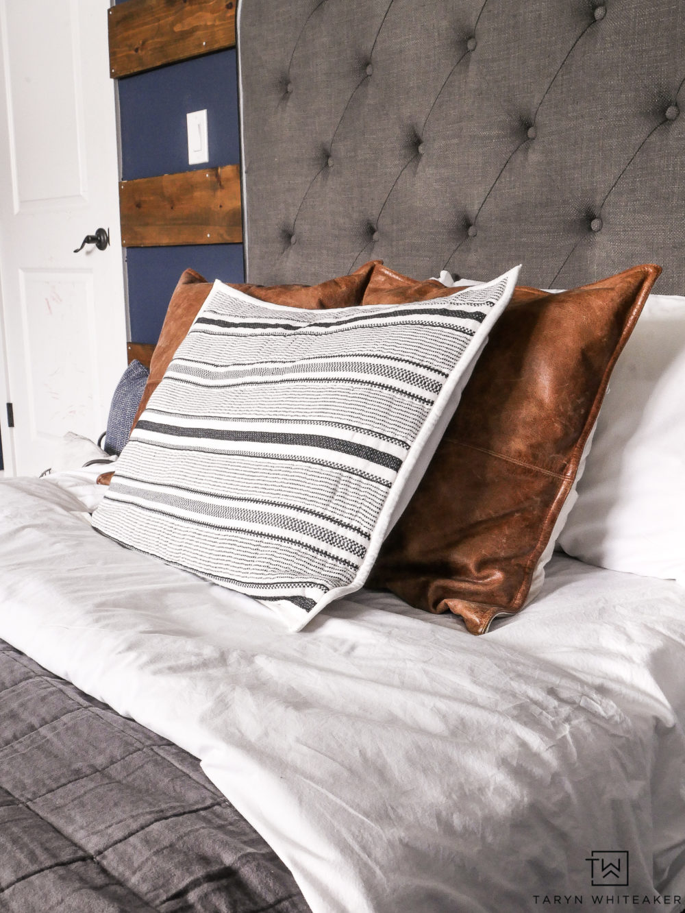 Modern farmhouse bedding with gray duvet, cognac leather pillows and pops of black and white!