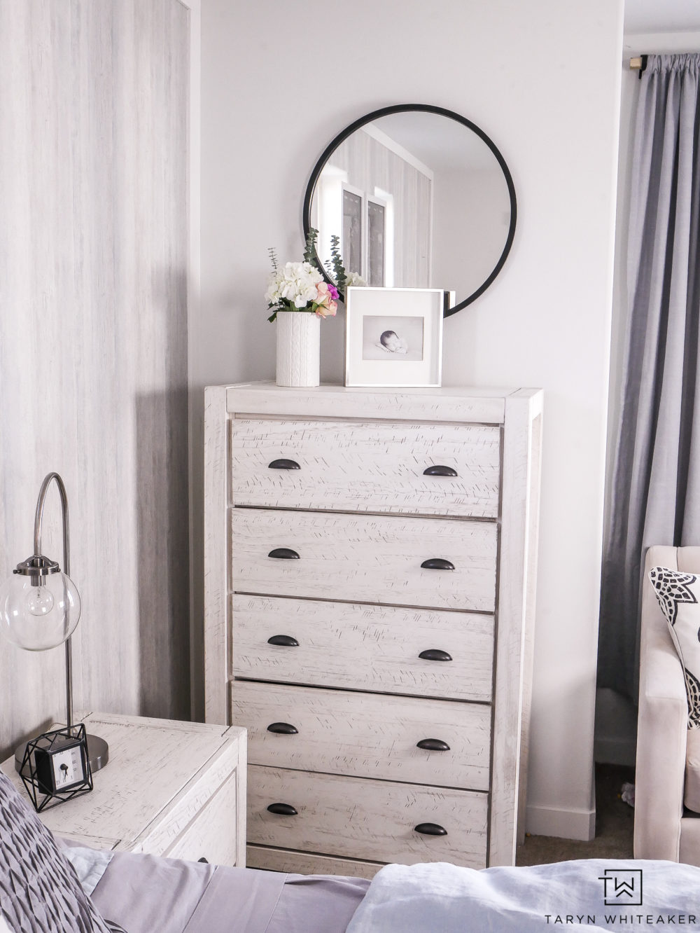 White washed dresser with black modern mirror. 