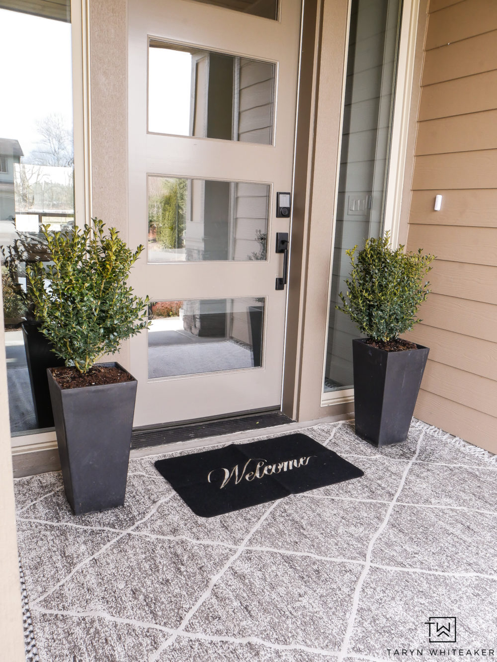 Classic spring porch decor with layered rugs and boxwood planters