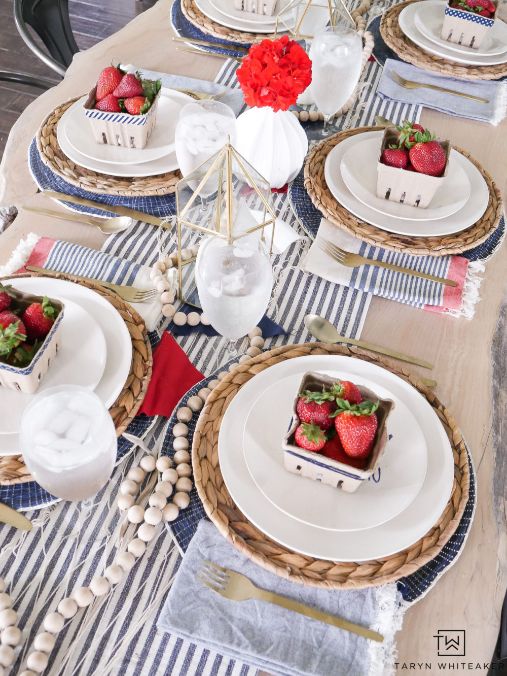 Nautical inspired table setting with gold lanterns, tickling table runner and fresh berries!