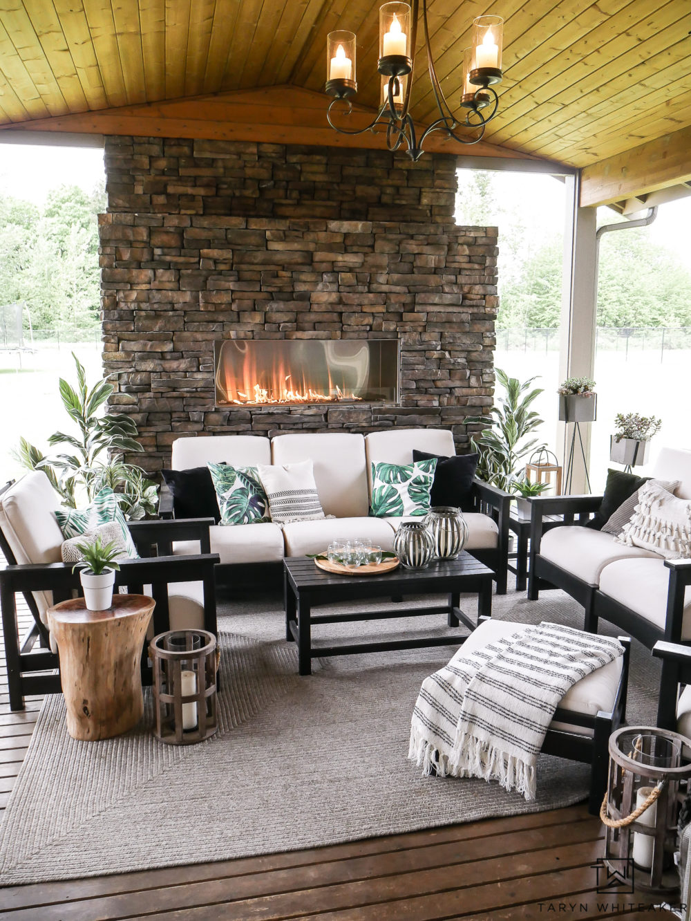 Black and White Outdoor living space with pops of tropical palms. Great take on Modern Coastal Decor. 