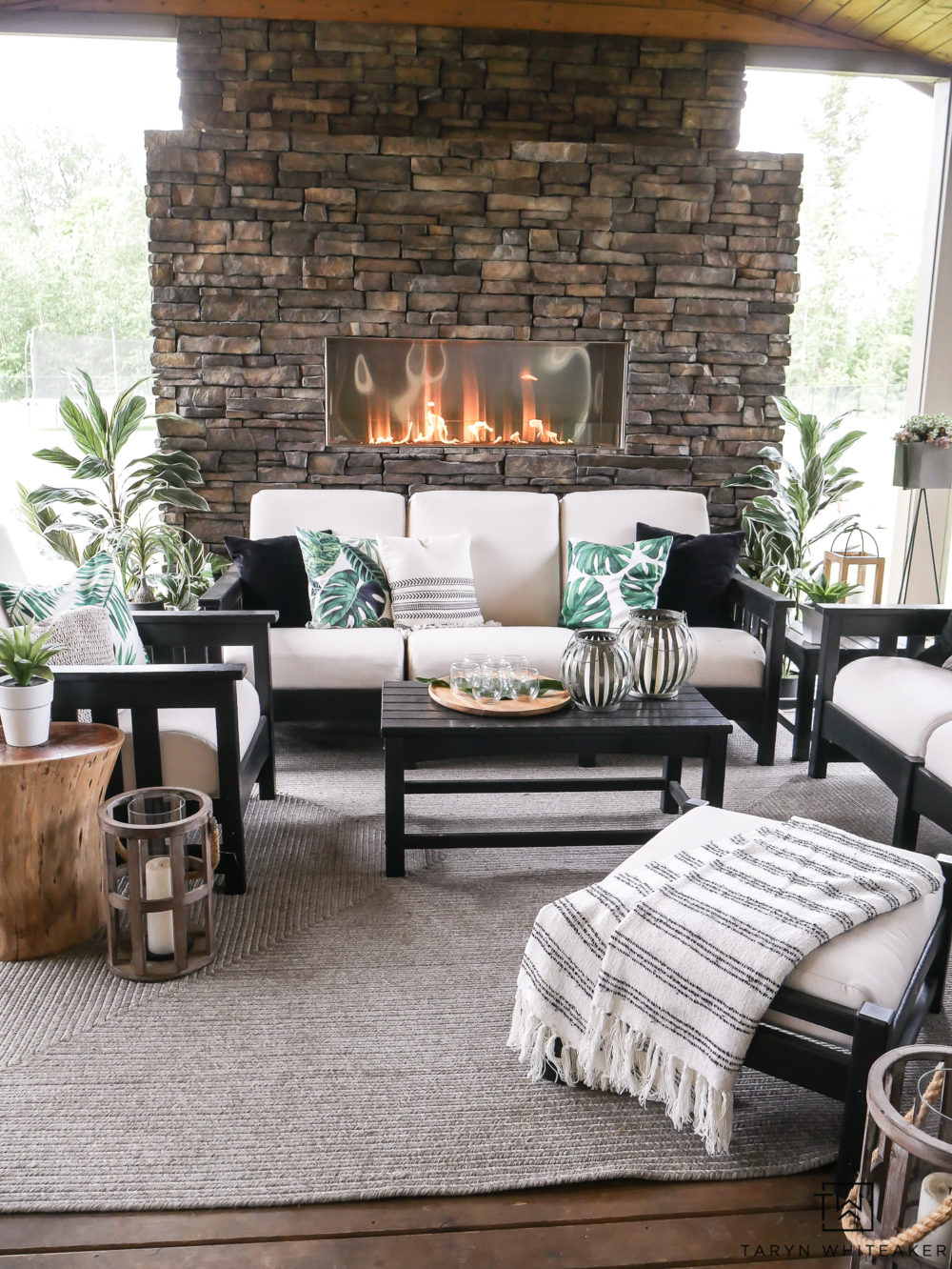 Black and White Outdoor living space with pops of tropical palms. Great take on Modern Coastal Decor. 