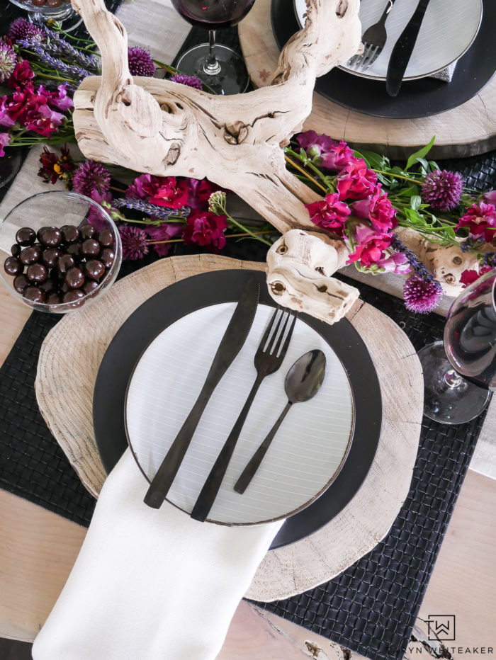 Beautiful black and white rustic modern tablescape with pops of earth tones! Love  how the purple and pink flowers look on the centerpiece. 