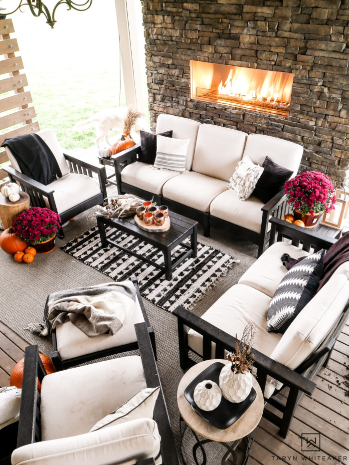 Learn how to turn your outdoor living space into a cozy fall escape using pumpkins, mums and plaid blankets. This outdoor fall decor is simple and inviting. 