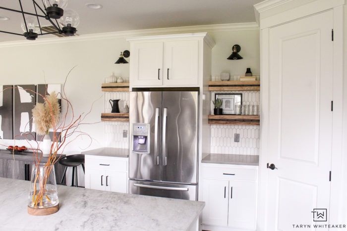 Black and White kitchen with floating open shelves and black industrial kitchen sconces. 