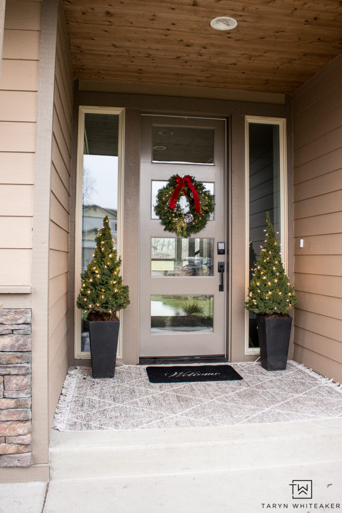 Keep it simple with this Classic Christmas Porch. Featuring layered porch rugs, mini Christmas trees and a fresh green wreath with red bow!