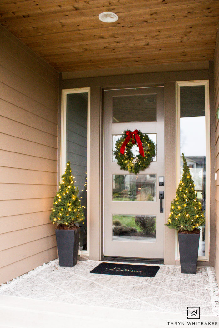 Keep it simple with this Classic Christmas Porch. Featuring layered porch rugs, mini Christmas trees and a fresh green wreath with red bow!