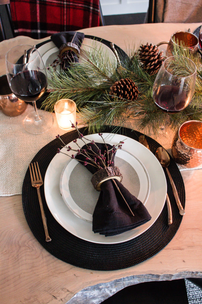 Combine rustic natural elements and a little Christmas glam to create this sleek Rustic Chic Christmas Table with black and white dishes and pops of greens.