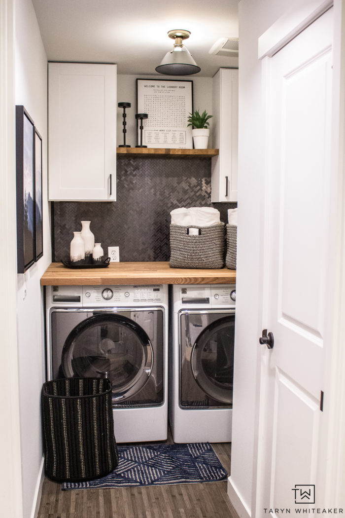 Love this Small Laundry Room Makeover ! The modern black and white laundry room with wood accents looks so chic. 