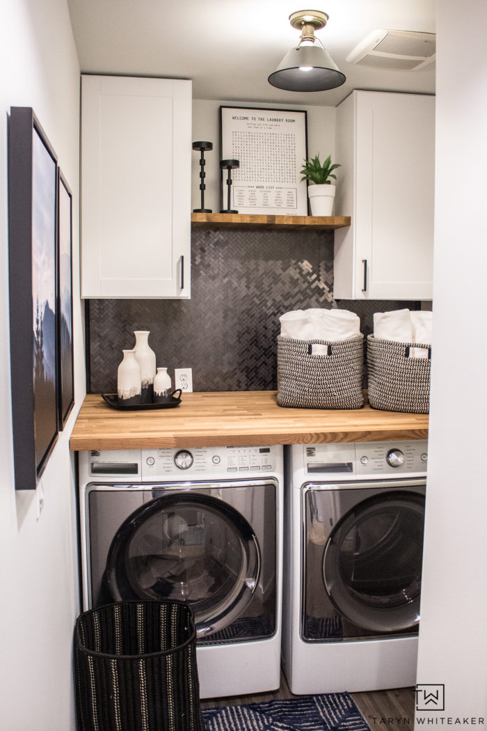 Love this Small Laundry Room Makeover ! The modern black and white laundry room with wood accents looks so chic. 