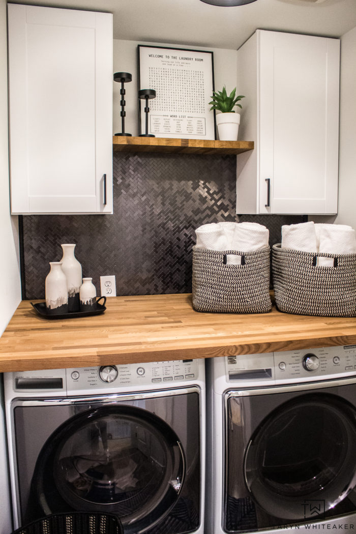 Love this Small Laundry Room Makeover ! The modern black and white laundry room with wood accents looks so chic. 