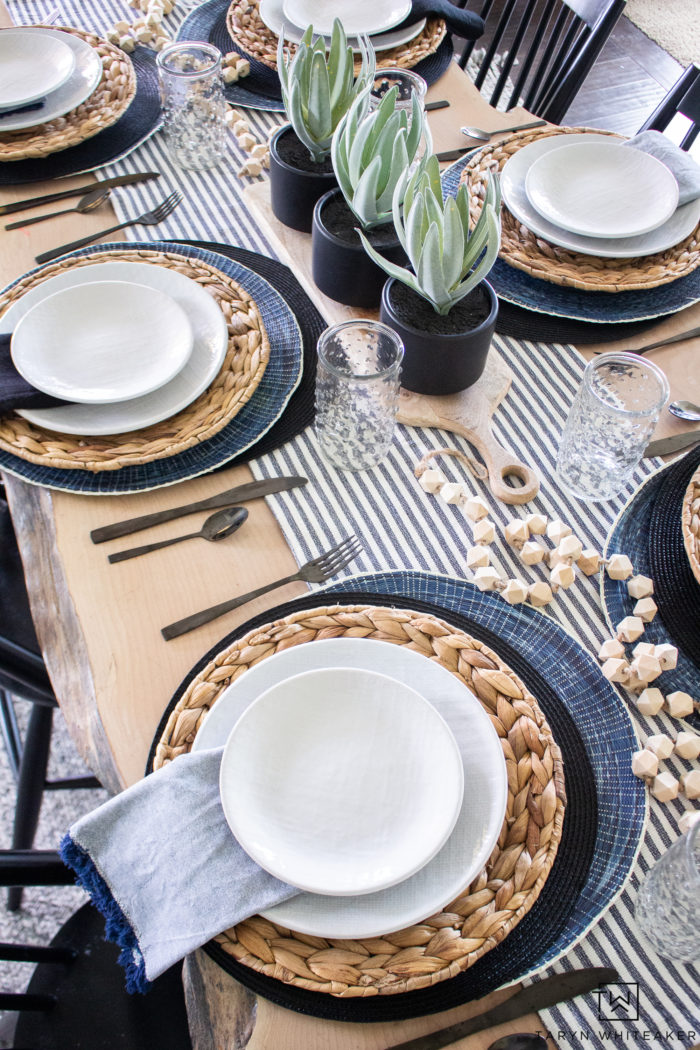 Black and White and navy spring tablescape using a variety of layered place mats and wood tones. 