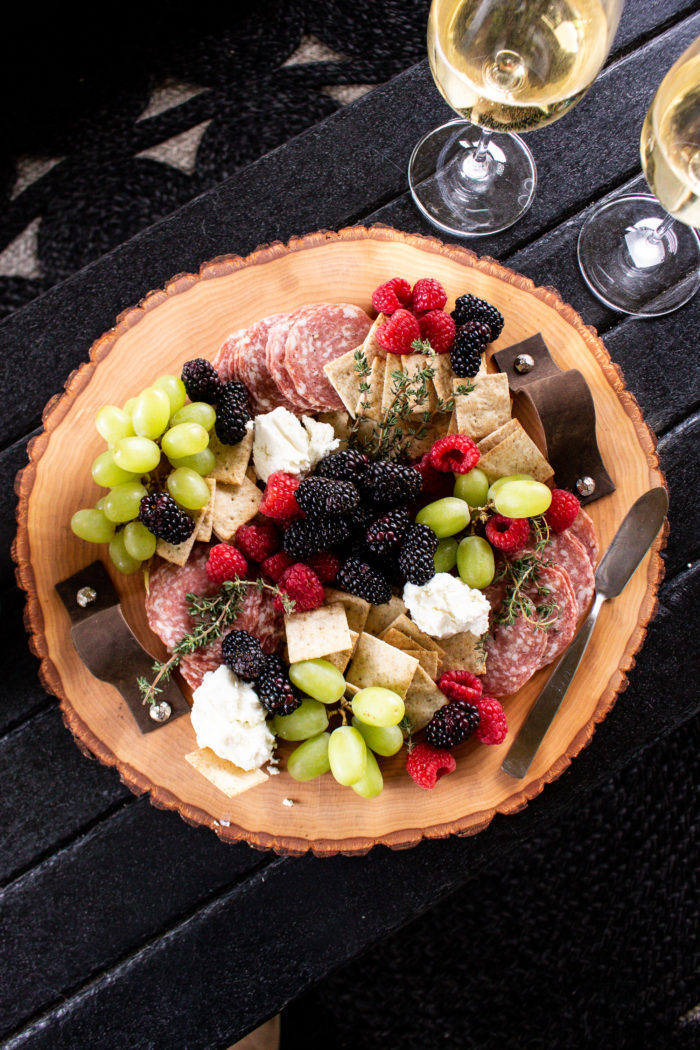 Learn how to make this DIY Wood Charcuterie Board using a wood round and leather straps! Easy 30 minute craft! 