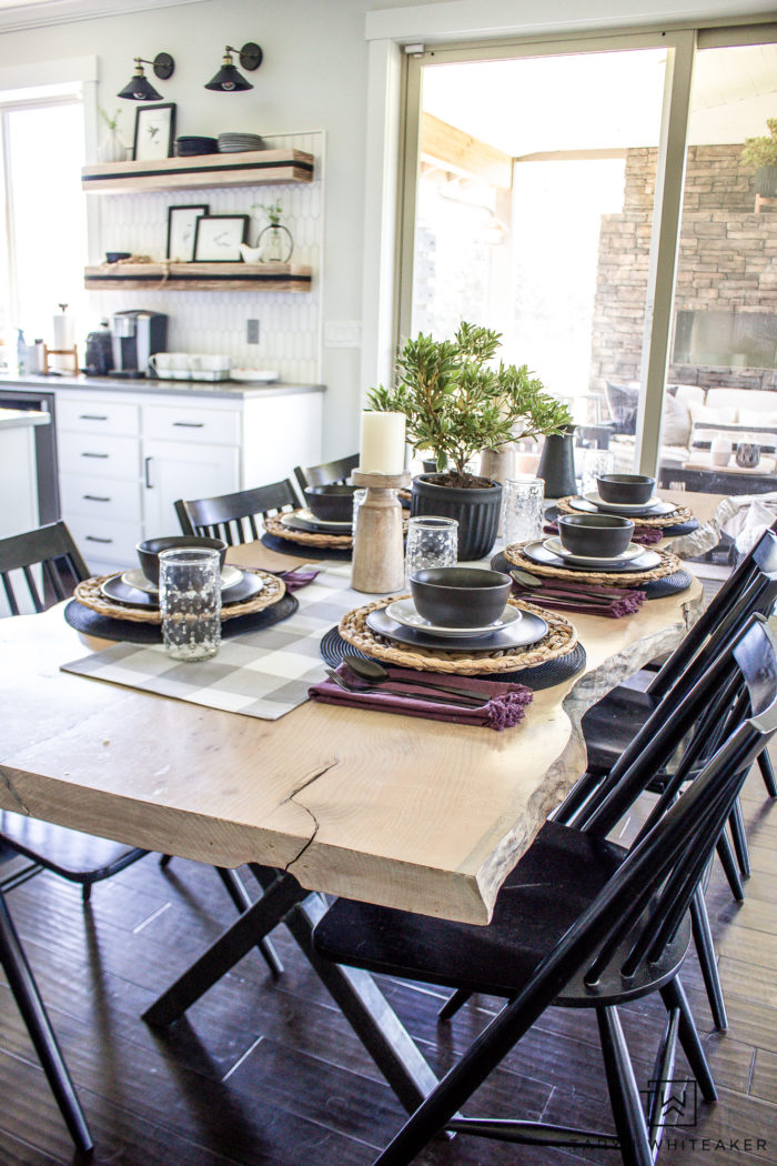 Organic modern table decor with black dishes and fresh greens. 