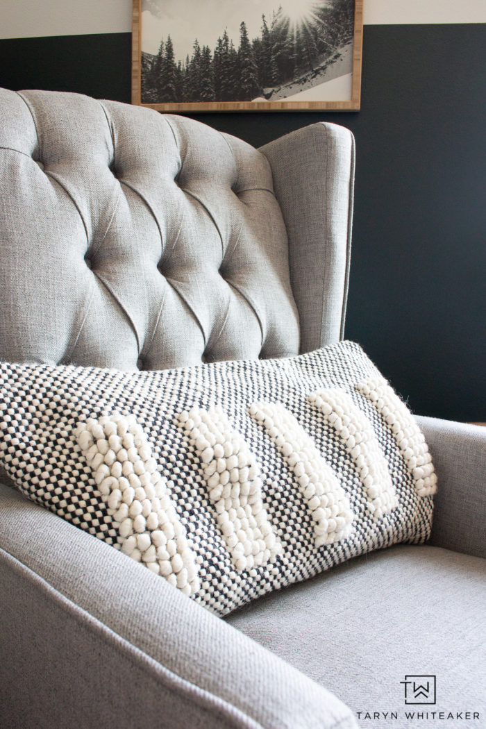 Light gray tufted recliner with cozy neutral throw pillow. 