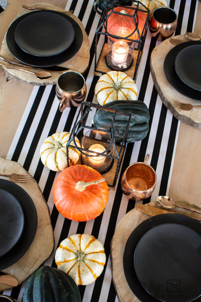 Recreate the look of this modern Halloween table decor with black and white striped table runner and heirloom pumpkin centerpiece. 