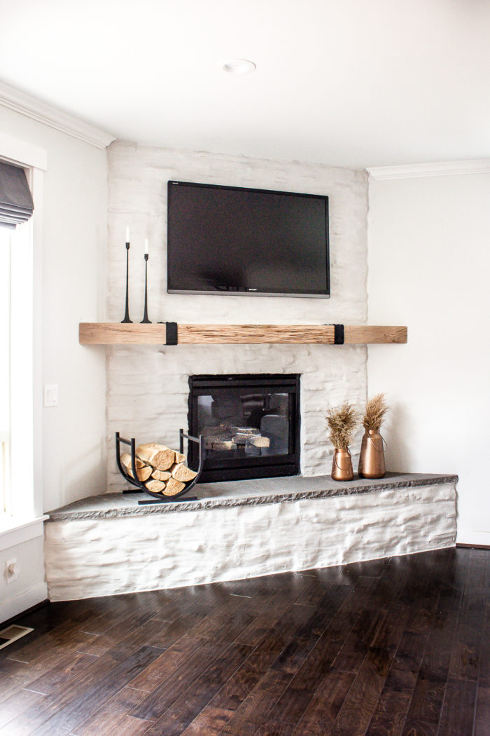 Take your dark stone fireplace and turn it into something more modern and chic with this stone fireplace makeover on a budget!