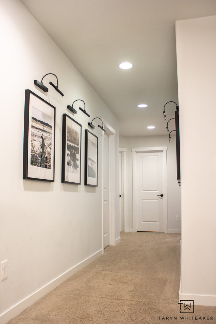 Spruce up your boring hallway with this Black and White Hallway Gallery Wall using personal pictures and wireless sconces!