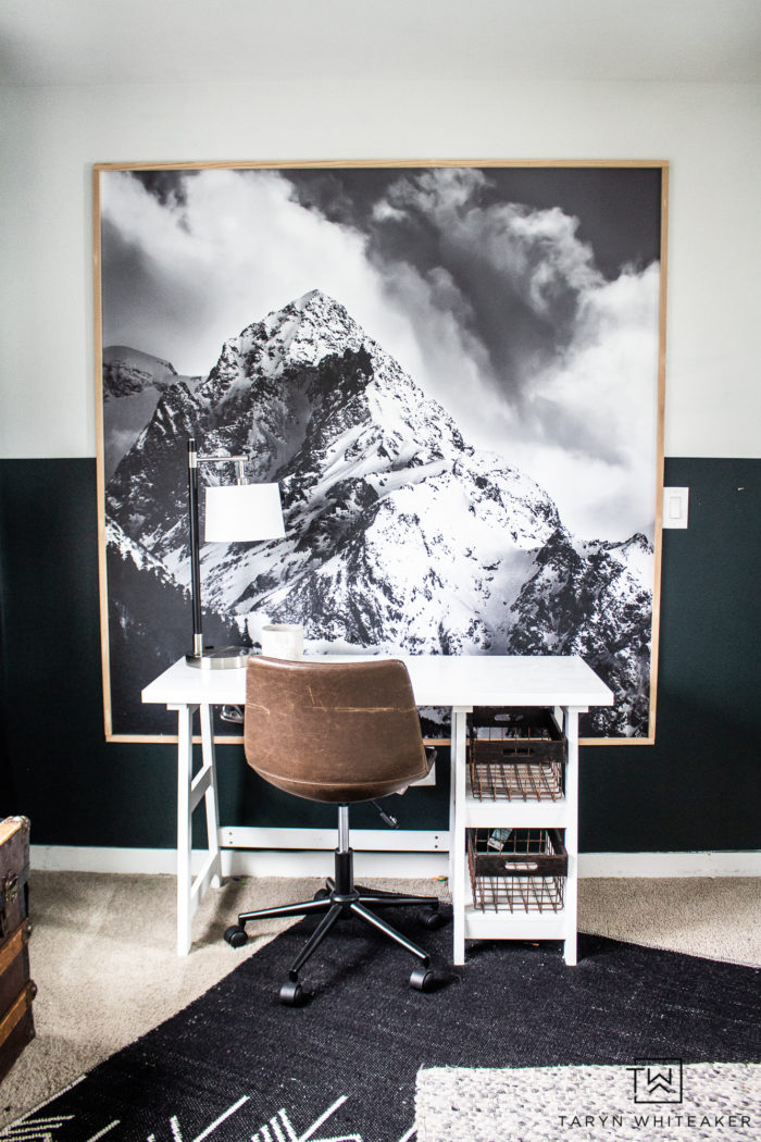 Bedroom desk space with large mountain print and white modern desk. 