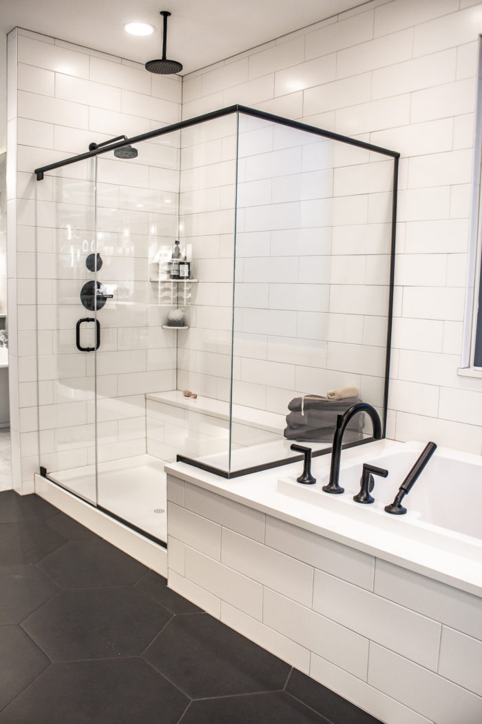 Black and White farmhouse Bathroom with black hexagon flooring and large white subway tile 